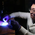 Purdue University postdoctoral student Yujie Shan examines 3D printed items in Huachao Mao’s Additive and Intelligent Manufacturing Lab. Mao and his team are improving upon traditional fabrication methods and 3D printing to construct multilevel microfluidic devices as small as 10 microns deep and 100 microns wide. (Purdue University photo/John O’Malley)