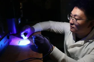 Purdue University postdoctoral student Yujie Shan examines 3D printed items in Huachao Mao’s Additive and Intelligent Manufacturing Lab. Mao and his team are improving upon traditional fabrication methods and 3D printing to construct multilevel microfluidic devices as small as 10 microns deep and 100 microns wide. (Purdue University photo/John O’Malley)