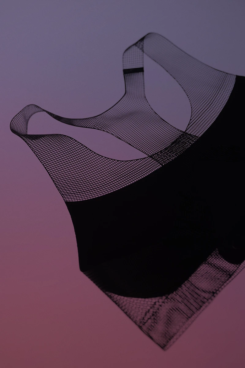 Front view of Nike FlyWeb 3D-printed sports bra showing TPU lattice structure on gradient background.