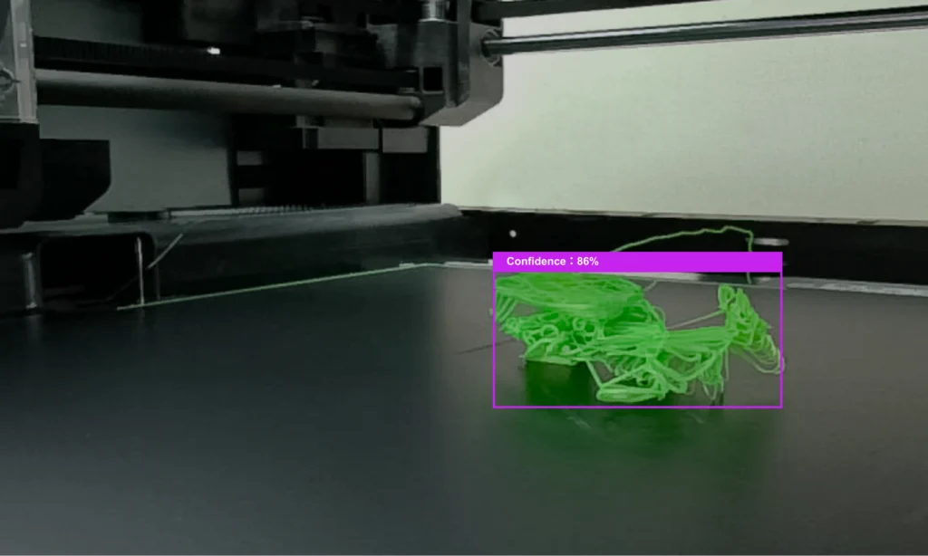 Bambu Lab X1 AI camera highlights green spaghetti failure on print bed