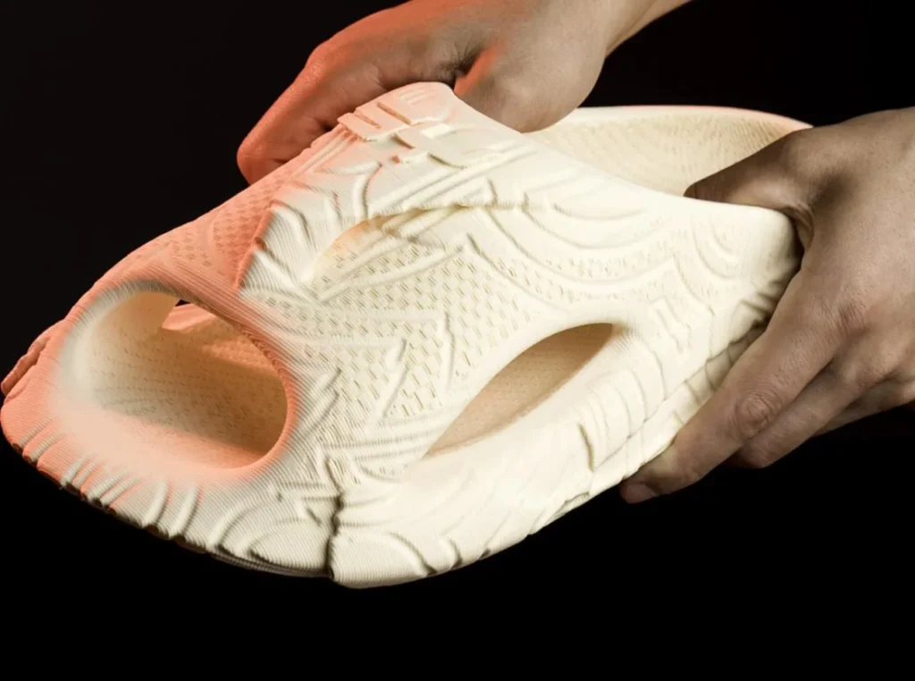 Hands flex a 3D-printed Syntilay slide showing intricate lattice