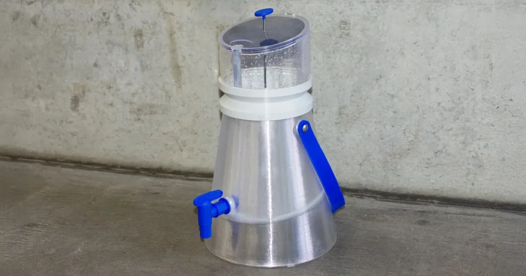 Full view of the 3D-printed ‘Water from Air’ device with transparent base, colored lid, and spigot tap.