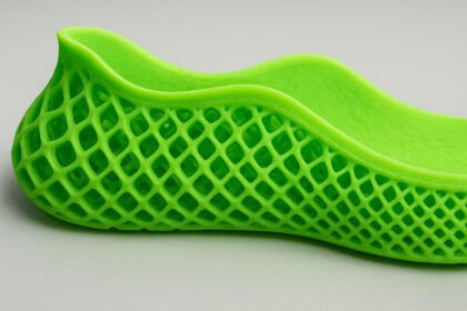 A bright green 3D-printed lattice shoe showing its mesh structure and smooth upper design.