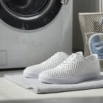 3D printed TPU lattice shoes beside a washing machine with a laundry bag for safe cleaning
