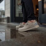 Person wearing 3D printed lattice shoes near a puddle after rain